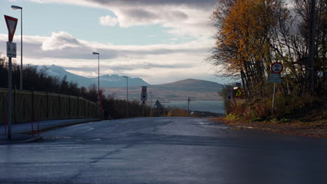 Fahrende-Landfahrzeuge-Und-Fußgänger,-Die-An-Einem-Herbsttag-In-Tromsø,-Norwegen,-Auf-Der-Straße-Spazieren