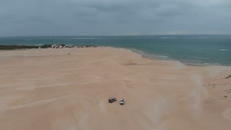 Wide-shot-of-group-of-car-vehicle-rides-on-desert-dune-at-western-Australia,-aerial