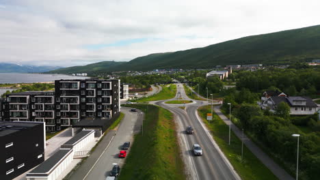 Drone-flight-along-E8-road-next-to-fjord-in-Tromso,-Norway