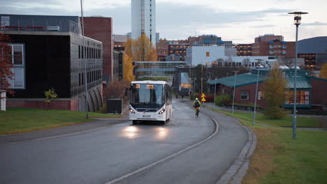 Autobús-De-Pasajeros-Y-Bicicleta-En-La-Calle-Asfaltada-En-El-Parque-Empresarial-De-Tromso,-Noruega