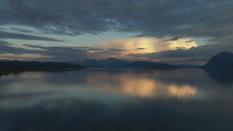 Impresionante-Vista-De-La-Puesta-De-Sol-Sobre-El-Tranquilo-Fiordo-En-El-Norte-De-Noruega,-Vívido-Reflejo-De-Las-Nubes