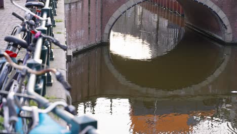 Bicicletas-Estacionadas-Junto-Al-Canal-En-Ámsterdam,-Países-Bajos.