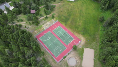 Summer-Camp-Outdoor-Basketball-and-Tennis-Courts-Surrounded-by-Evergreen-Trees