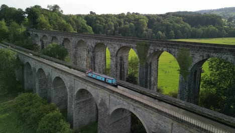 Narrowboat-crossing-canal-over-Chirk-Aqueduct,-Railway-Viaduct-in-background---stationary-aerial-drone---Welsh,-English-border,-Sept-23