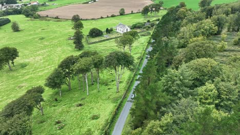 Aerial-circling-old-church-and-graveyard-with-fertile-green-farmland-at-Curraghmore-Waterford-Ireland-on-a-September-afternoon