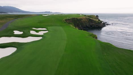 aerial-drone-shot-of-the-6th-hole-at-Pebble-Beach-Golf-Links-next-to-the-ocean-in-California