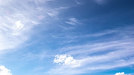 Hermosas-Nubes-Cirros-Y-Cúmulos-Flotan-En-Lo-Alto-De-Los-Cielos-Azules-Iluminados-Por-El-Sol-Formando-Formas-Y-Patrones-En-Un-Lapso-De-Tiempo-En-Movimiento