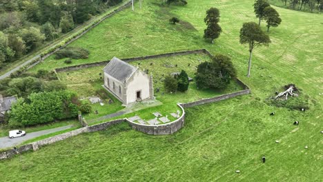 Vuelo-Aéreo-En-Círculos-Sobre-La-Antigua-Iglesia-Y-El-Cementerio-De-Waterford,-Irlanda,-En-Un-Día-Aburrido