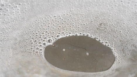 Water-boiling-and-evaporating-steam-from-a-Teflon-Pan---macro