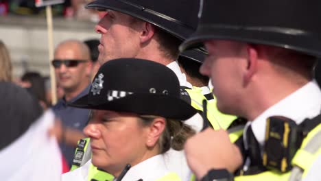 Metropolitan-police-officers-stand-together-in-line-and-monitor-a-protest-on-Trafalgar-Square-on-a-hot-and-sunny-day