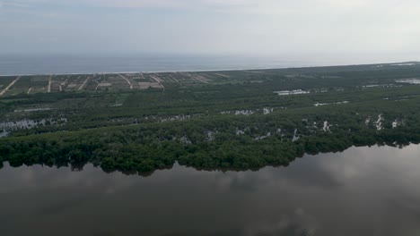 Vista-De-Drones,-Donde-El-Océano-Pacífico-Y-La-Laguna-De-Manialtepec-Se-Unen-Cerca-De-Puerto-Escondido,-México