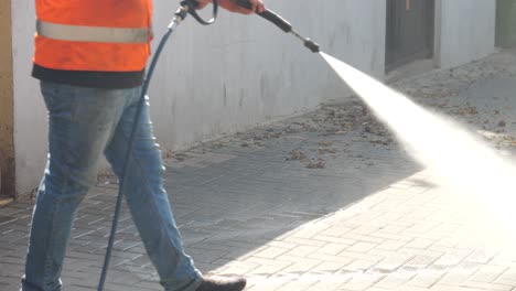 Worker-cleans-the-walkway-with-a-pressure-washer
