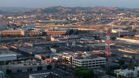 Aerial-View-Over-East-Los-Angeles-With-Golden-Hour-Sunset-Light-Seen-On-Rooftop-Buildings
