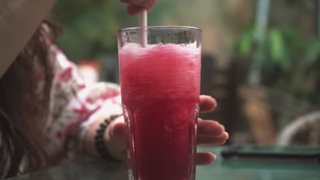 Refreshing-Swirl:-Close-Up-of-a-Red-Slushy-Drink-Being-Mixed-in-a-Glass