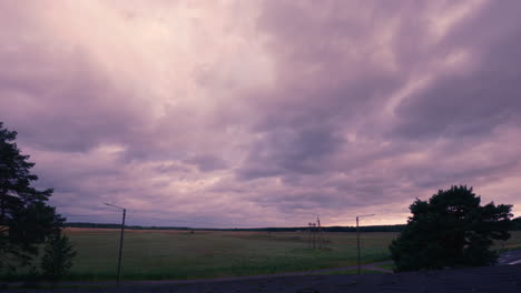 Story-cloud-overhead-timelapse-through-the-agricultural-field,-Purple-sky,-Windy-nature-concept