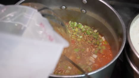 Adding-water-to-pot-of-simmering-soup-or-stew