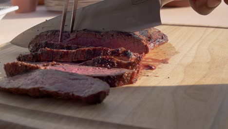 Person-slicing-cooked-meat-on-a-cutting-board