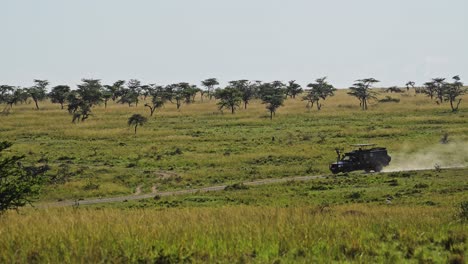 Slow-Motion-Shot-of-Four-wheel-drive-jeep-driving-across-the-plain-on-dustry-road-track,-African-Wildlife-in-Maasai-Mara-National-Reserve,-Kenya,-Africa-Safari-Animals-in-Masai-Mara-North-Conservancy