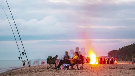 Zeitraffer-Eines-Lagerfeuers-Am-Strand-Mit-Einer-Gruppe-Feiernder-Und-Angelnder-Menschen-Am-Sandstrand