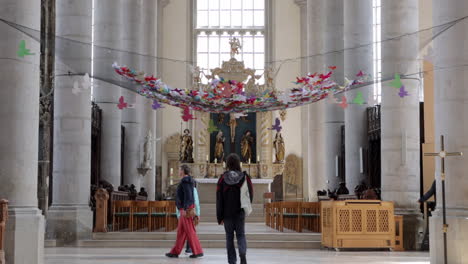 Gente-Mirando-Alrededor-De-La-Iglesia-De-San-Jorge-Con-El-Altar-Del-Coro-En-Nordlingen,-Alemania