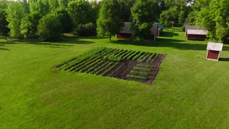 push-in-aerial-drone-shot-of-a-garden-in-the-middle-of-a-yard-on-a-farm