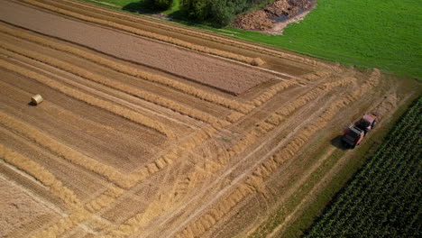Aerial-top-down-shot-of-agricultural-machinery-harvesting-on-wheat-field-in-Poland-at-summer