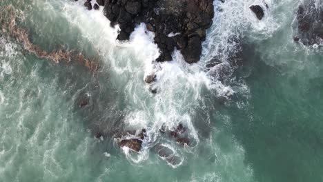 Incredible-rising-shot-of-waves-crashing-on-the-tip-of-a-rocky-point