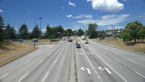 Vehicles-Passing-Through-The-Road-And-Intersections-On-A-Sunny-Day