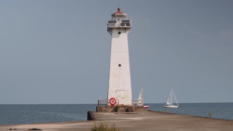 Zwei-Boote-Passieren-Den-Kleinen-Leuchtturm.-Aufnahme-Der-Leuchttürme-Am-Urlaubsort-Sodus-Point-In-New-York-An-Der-Landspitze-Am-Ufer-Des-Lake-Ontario