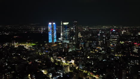 Aerial-view-circling-the-illuminated-downtown-of-CDMX,-nighttime-in-Mexico-city