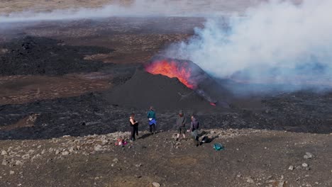Excursionistas-Aventureros-Disfrutando-De-Una-Vista-Mágica-De-Un-Volcán-En-Erupción-En-Islandia