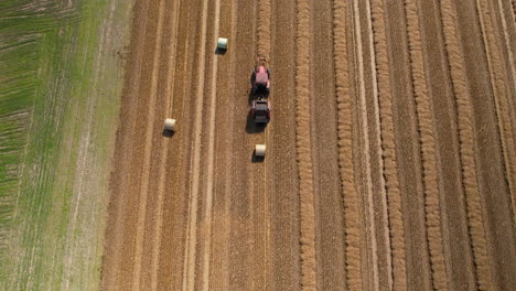 Top-down-aerial-of-a-tractor-working-in-the-field-during-straw-baling
