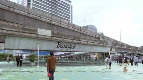 BTS-Skytrain-with-Traffic-sky-walk-area-connects-Siam-Discovery-department-store-and-MBK-Center-over-the-Pathumwan-Intersection-in-evening,-Bangkok-Thailand
