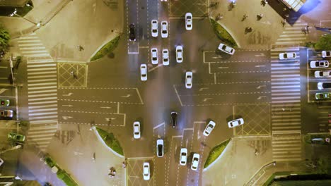 Von-Oben-Nach-Unten-Aufgenommene-Luftaufnahmen-Einer-Stark-Befahrenen-Kreuzung-In-China,-Chengdhu,-Mit-Weißen-Autos-Und-Einem-Grünen-Taxi