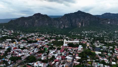 Flying-over-the-townscape-of-Tepoztlan,-Morelos,-cloudy-day-in-Mexico---Aerial-view