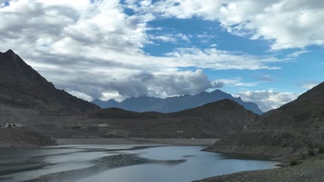 Eine-Wunderschöne-Landschaftsansicht-Des-Sadpara-Sees-In-Skardu-Gilgit-Baltistan-–-Ein-See-Mit-Bergen-Im-Hintergrund-Und-Wolken-über-Dem-Blauen-Himmel