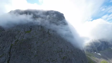 FPV-drone-embarks-on-an-exhilarating-ascent-up-a-massive-vertical-mountain-face,-a-thrilling-adventure-from-a-daring-perspective