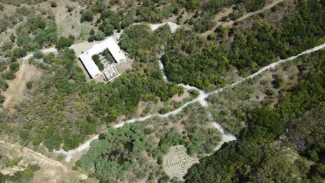 Aerial-establishing-shot-of-a-stone-maze-in-the-countryside-during-the-day