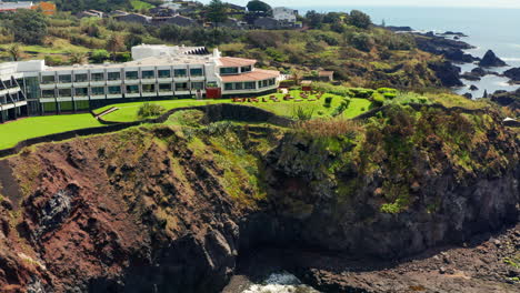 Cinematic-aerial-drone-shot-of-a-beautiful-resort-located-on-top-rocky-coastline-in-Sao-Miguel-island,-Azores---Portugal