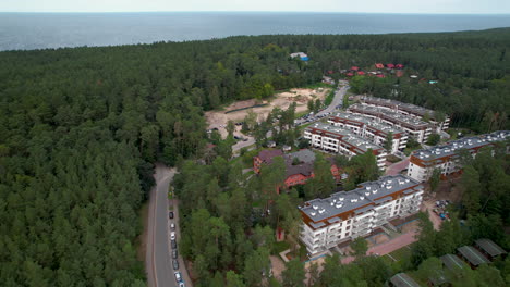 Aerial-backwards-shot-of-forest-landscape,-sea-and-residential-area-of-Stegna-in-Poland