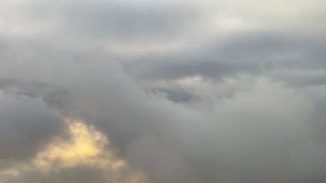 Volando-A-Través-De-Un-Cielo-Nublado-Justo-Antes-Del-Atardecer,-Con-Un-Sol-Anaranjado-Velado-Por-Nubes-Deshilachadas