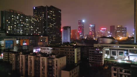 Nighttime-Aerial-View-of-Old-Chinese-Residential-Buildings-with-Modern-Skyscrapers