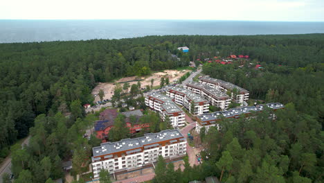 Aerial-dolly-above-hotel-room-complex-in-deep-forest-near-stegna-poland-beach