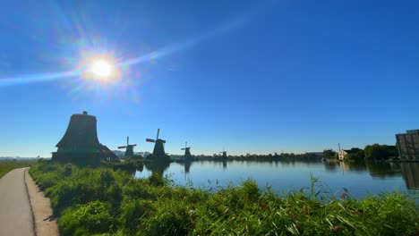 Sun-Shining-Bright-At-Dutch-mills-And-Green-Landscape-By-Lake-at-Zaanse-Schans