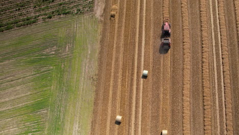 Aerial-top-down-shot-of-tractor-harvesting-agricultural-field-on-polish-countryside-in-summer