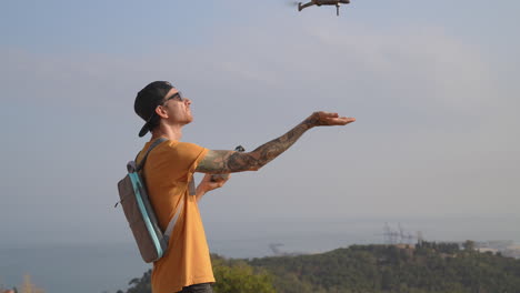 Drone-landing-on-travel-videographer-hand-after-flight