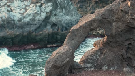 Rock-Formation-with-Hole-Along-the-Coastal-Los-Gigantes-Promenade-in-the-Tenerife-with-Ocean-Waves-in-the-Background