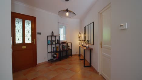Slow-dolly-shot-of-a-home-front-doorway-with-bookshelves-and-candles-burning