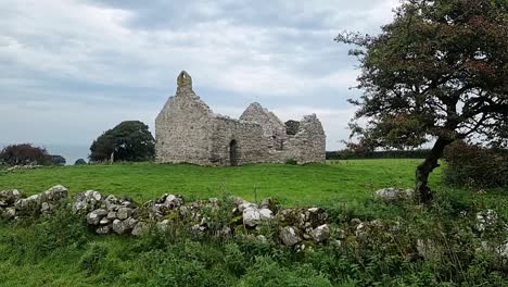 The-ruins-of-Capel-Lligwy-on-rural-Moelfre-countryside,-Anglesey,-North-Wales,-Handheld-shot