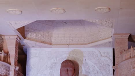isolated-red-stone-jain-god-holy-statue-in-meditation-from-different-angle-video-is-taken-at-Shri-Digamber-Jain-Gyanoday-Tirth-Kshetra,-Nareli-Jain-Mandir,-Ajmer,-Rajasthan,-India